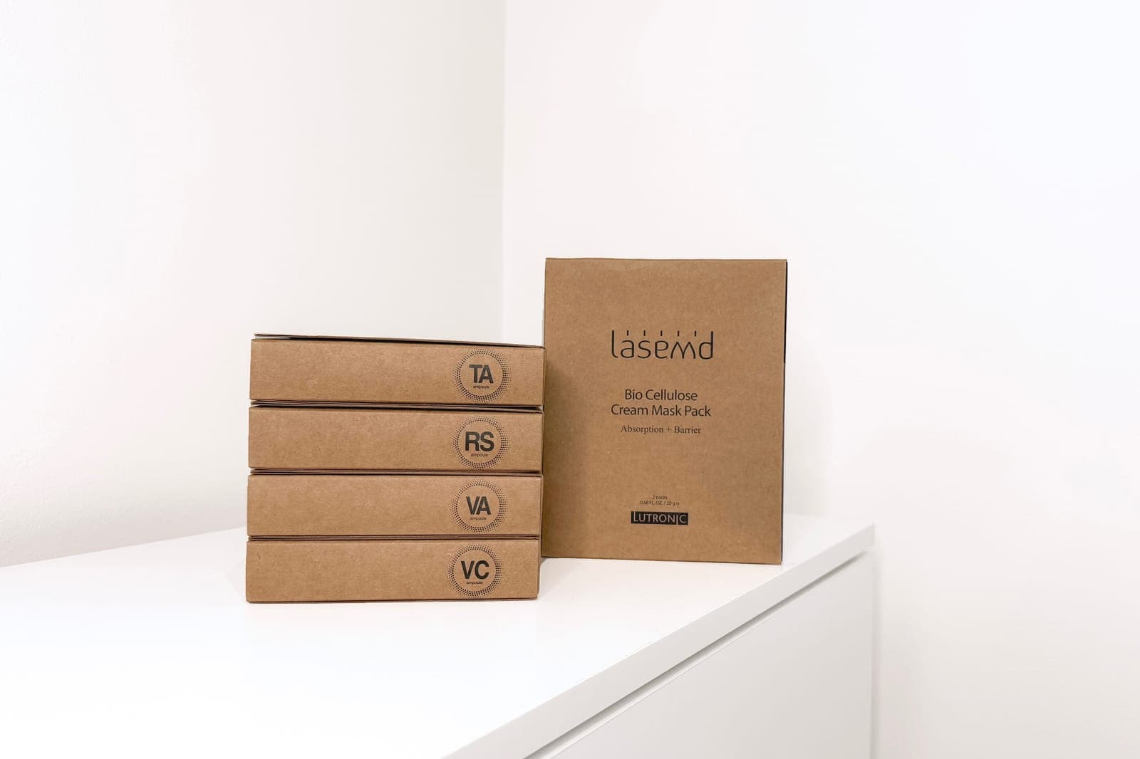 LaseMD take-home recovery cream boxes labelled TA, RS, VA and VC, with bio-cellulose cream masks